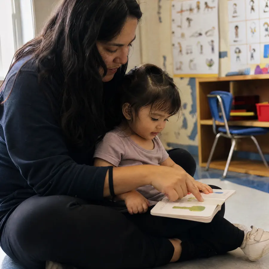 Parent and toddler reading together in Spanish